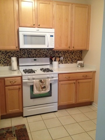 3016 Falling Waters Lane, Unit 3016 Lindenhurst, IL 60046 - Photo 7 of 21 a white stove top oven sitting inside of a kitchen