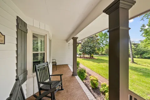 a living room with furniture kitchen view and a large window