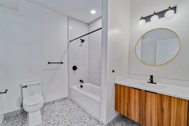 a bathroom with a sink a toilet and a mirror