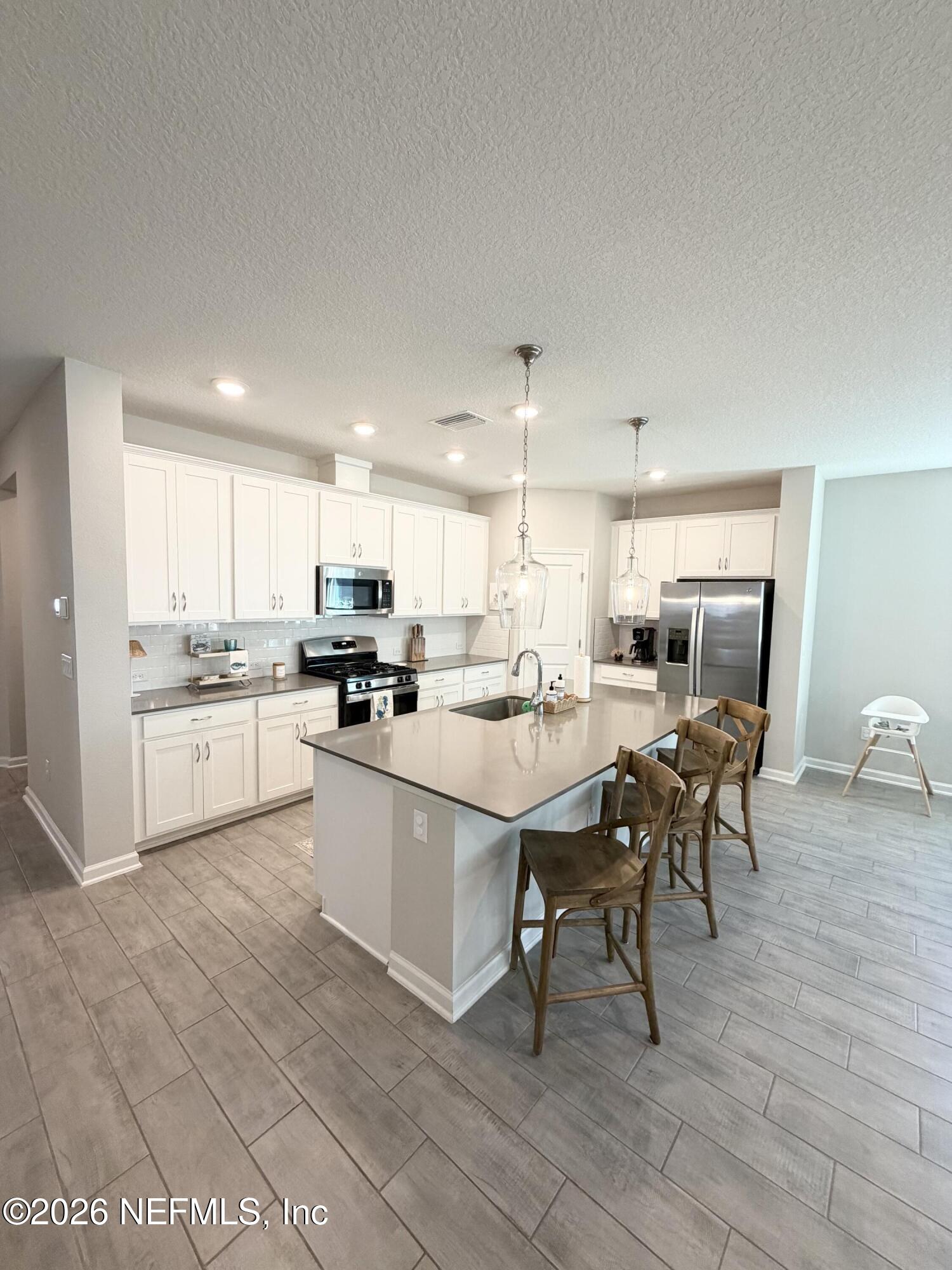 75457 Banyan Way Yulee, FL 32097 - Photo 15 of 36 a kitchen with a sink cabinets and wooden floor