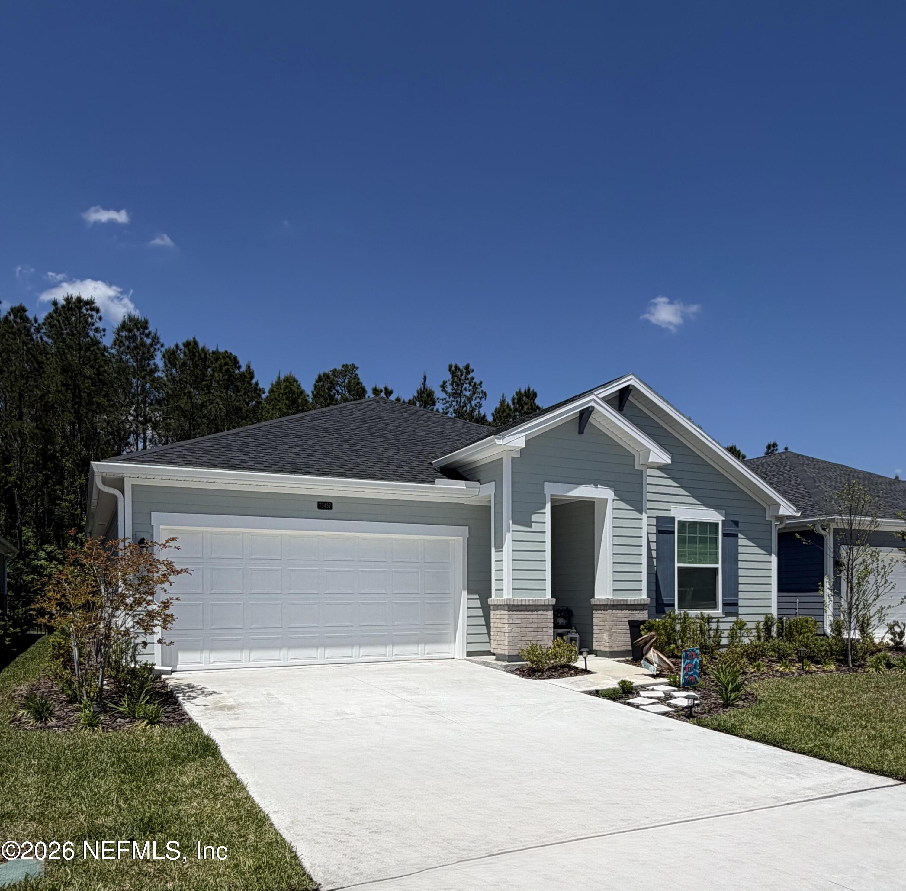 75457 Banyan Way Yulee, FL 32097 - Photo 2 of 36 a front view of a house with a yard and garage