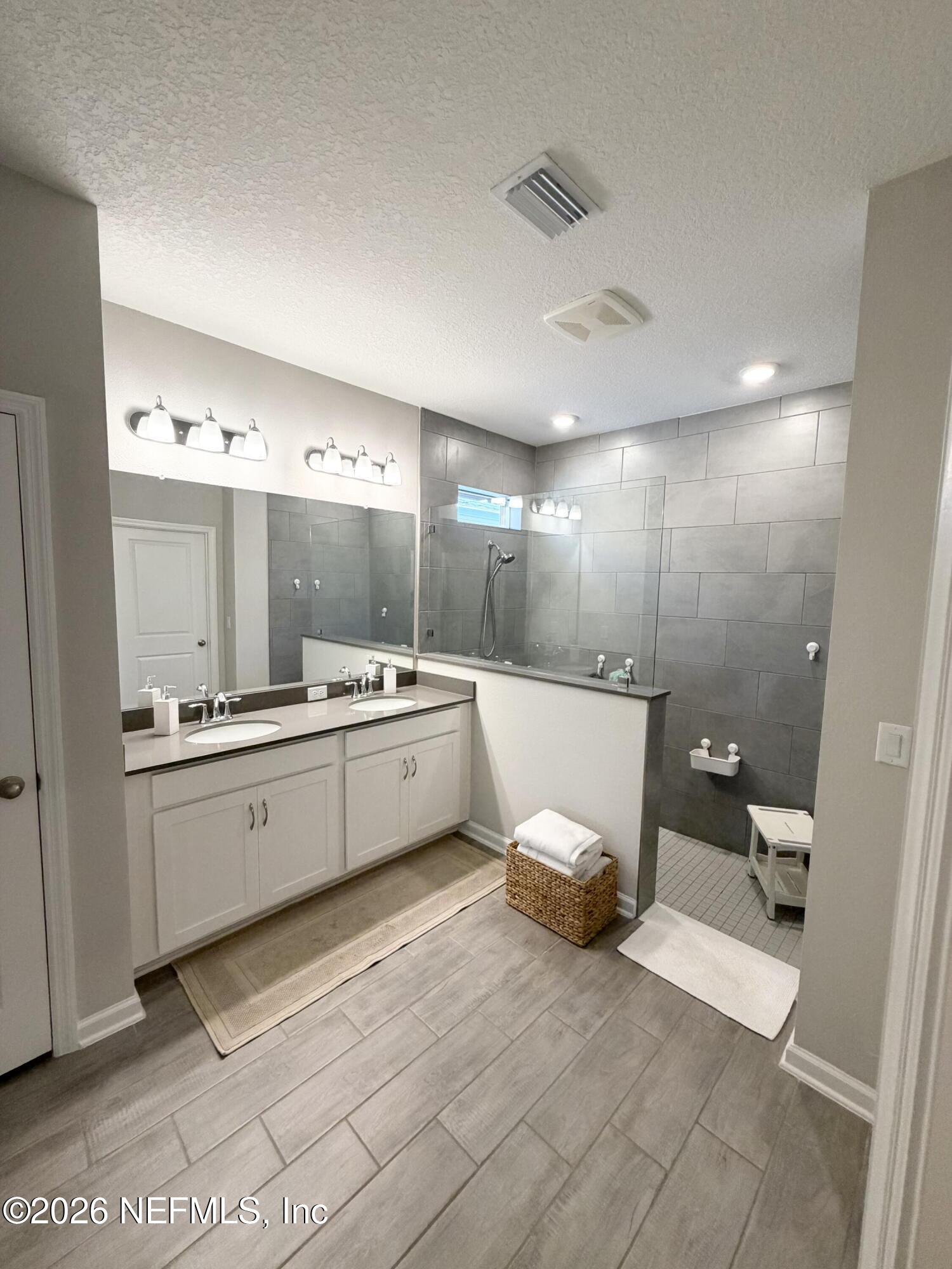 75457 Banyan Way Yulee, FL 32097 - Photo 25 of 36 a large bathroom with a double vanity sink a mirror and a toilet