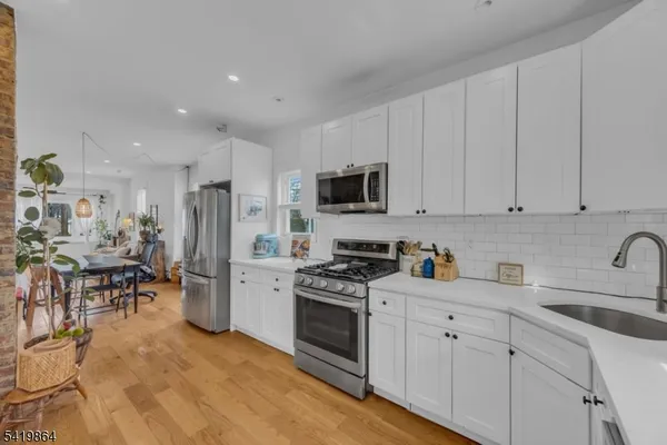 a kitchen with white cabinets and stainless steel appliances