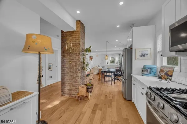 a kitchen with stainless steel appliances granite countertop a stove and a wooden floors