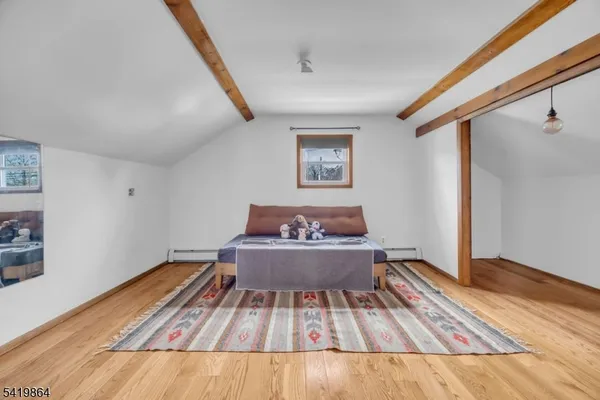 a view of room with wooden floor and furniture