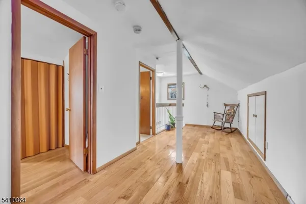 a view of a livingroom with wooden floor and staircase