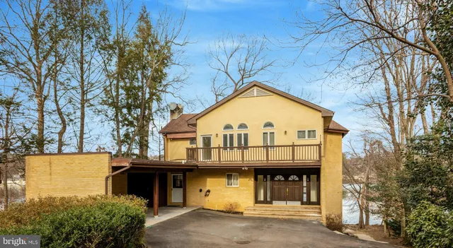 a view of a brick house with large windows and a large tree