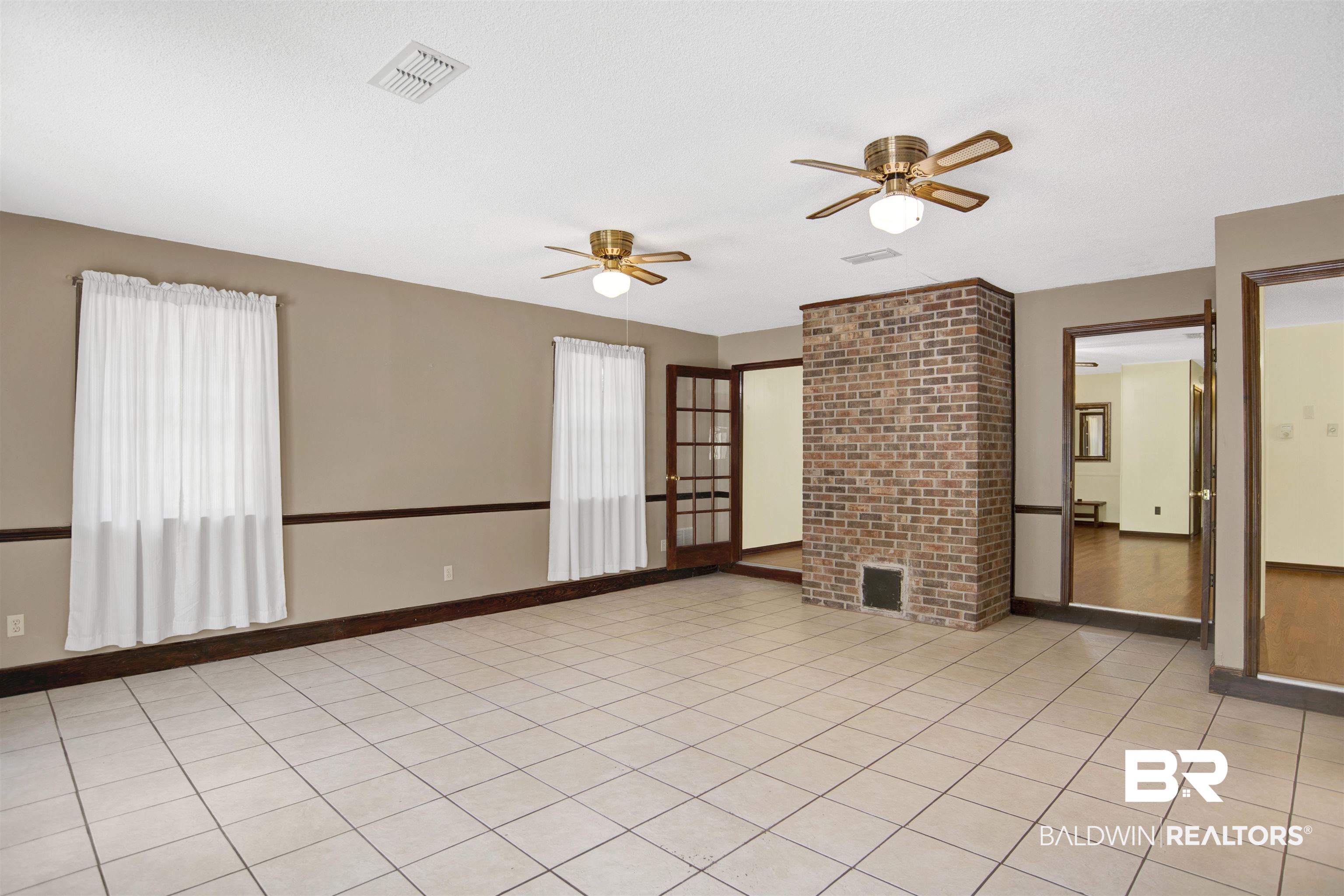 30888 Cemetery Road Daphne, AL 36527 - Photo 15 of 36 Spacious room featuring light-toned square tile flooring and neutral painted walls with dark wood trim