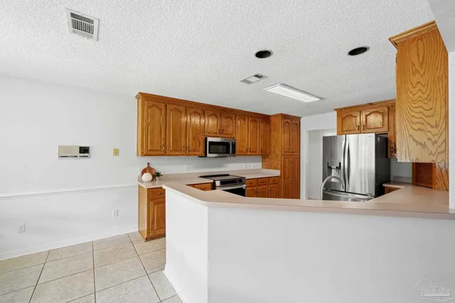 a kitchen with stainless steel appliances a stove refrigerator sink and microwave