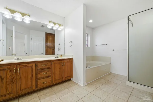 a spacious bathroom with a tub sink and mirror