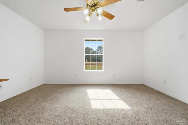 an empty room with a window and a ceiling fan
