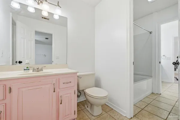 a bathroom with a granite countertop sink a toilet and shower