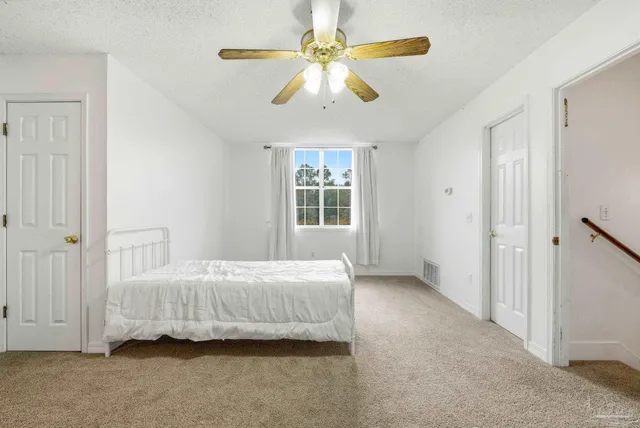 a bedroom with a bed and a ceiling fan