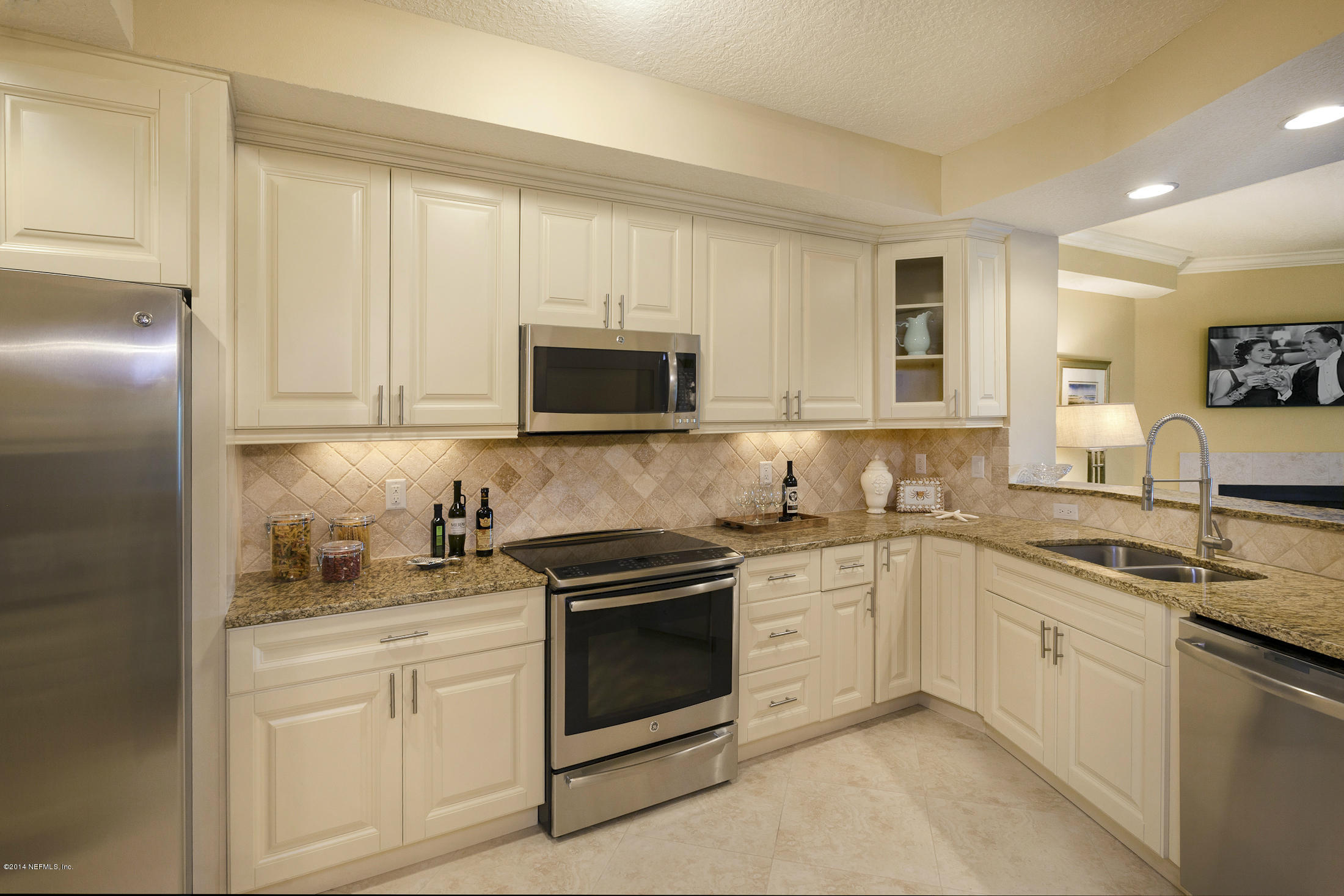 3958 Baymeadows Road, Unit 2202 Jacksonville, FL 32217 - Photo 5 of 9 a kitchen with white cabinets and white appliances
