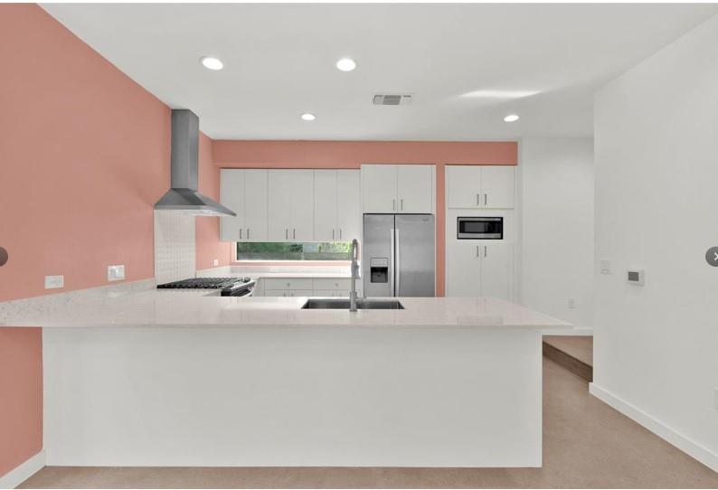 203 East 46th Street Austin, TX 78751 - Photo 4 of 13 Kitchen featuring white cabinetry, a peninsula, stainless steel appliances, light stone counters, and recessed lighting