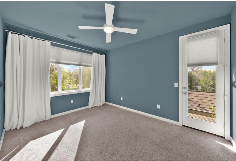 203 East 46th Street Austin, TX 78751 - Photo 9 of 13 Unfurnished bedroom featuring access to exterior, carpet floors, a ceiling fan, and multiple windows
