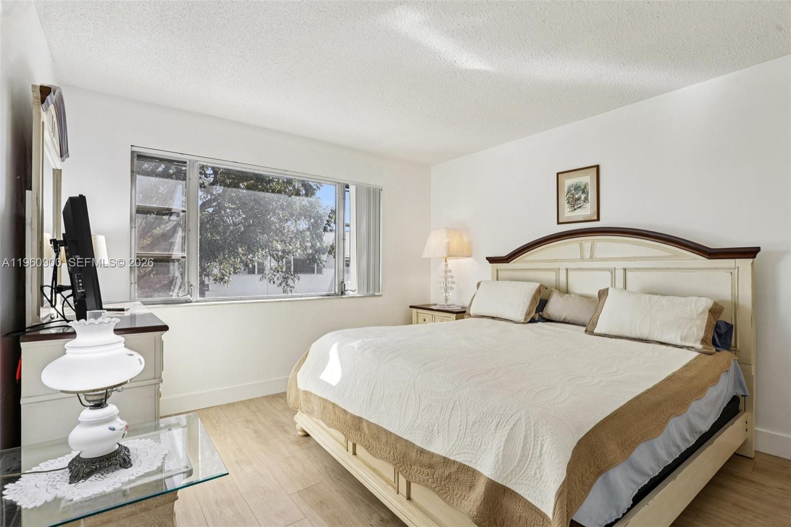 310 South Cypress Road, Unit 730 Pompano Beach, FL 33060 - Photo 19 of 26 a bedroom with a bed and dresser with mirror