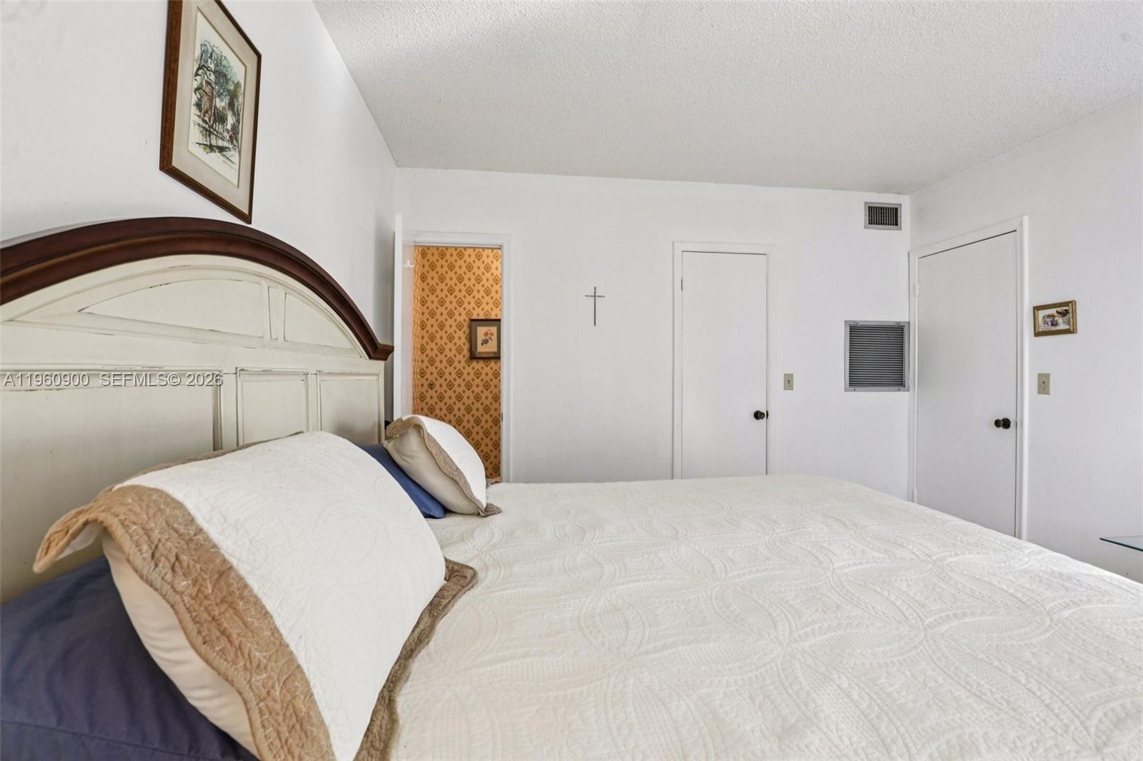 310 South Cypress Road, Unit 730 Pompano Beach, FL 33060 - Photo 20 of 26 a bedroom with a bed and a painting on the wall