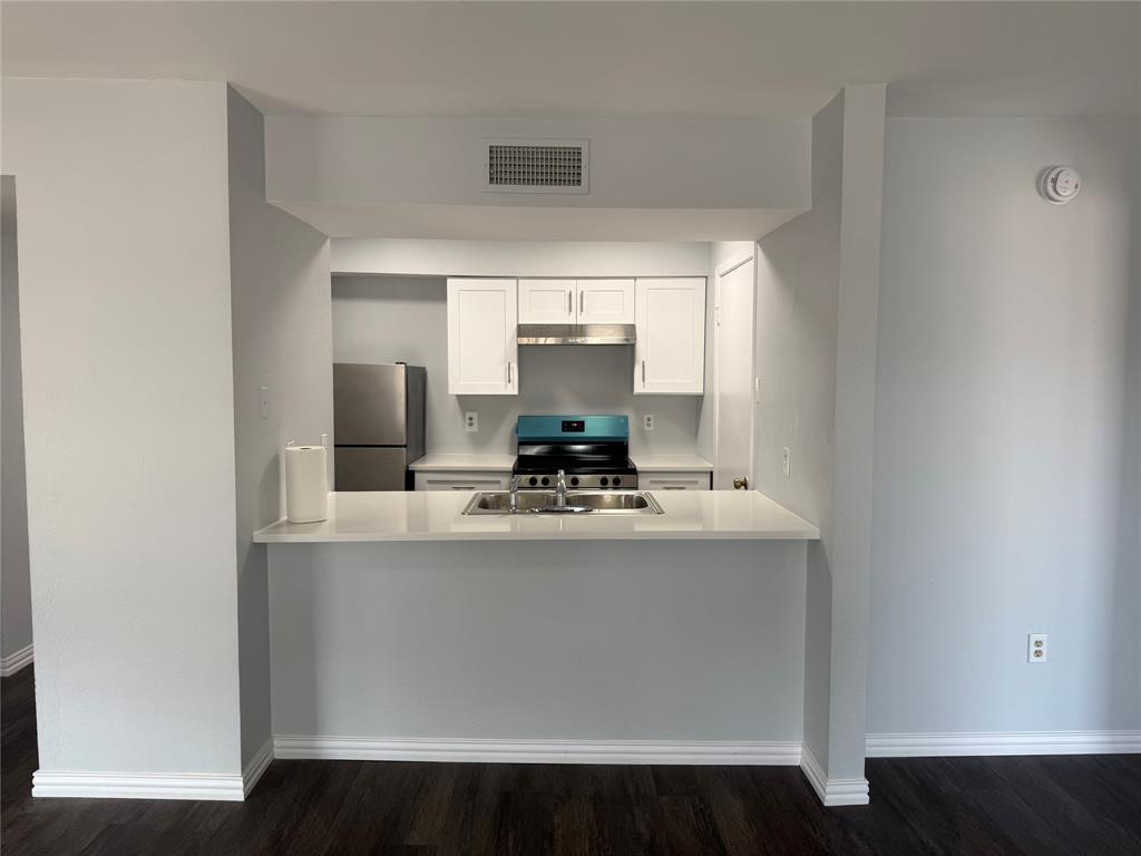 12482 Abrams Road Dallas, TX 75243 - Photo 2 of 4 a view of kitchen with stainless steel appliances wooden floor