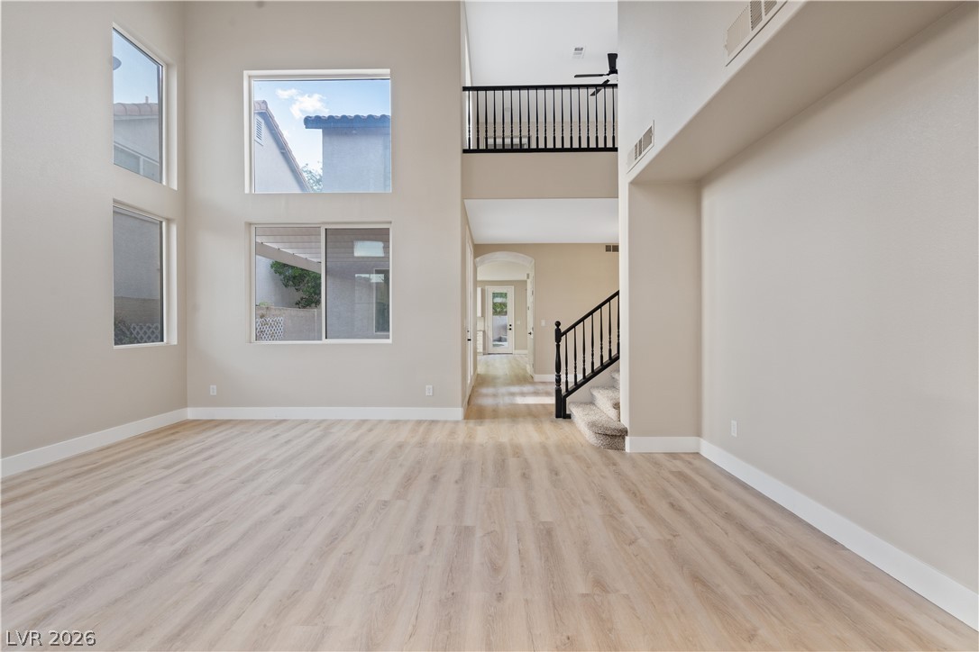 1662 Ravanusa Drive Henderson, NV 89052 - Photo 71 of 74 Voluminous ceilings and generous windows create a light-filled, open-concept living space with a grand staircase and second-story overlook.