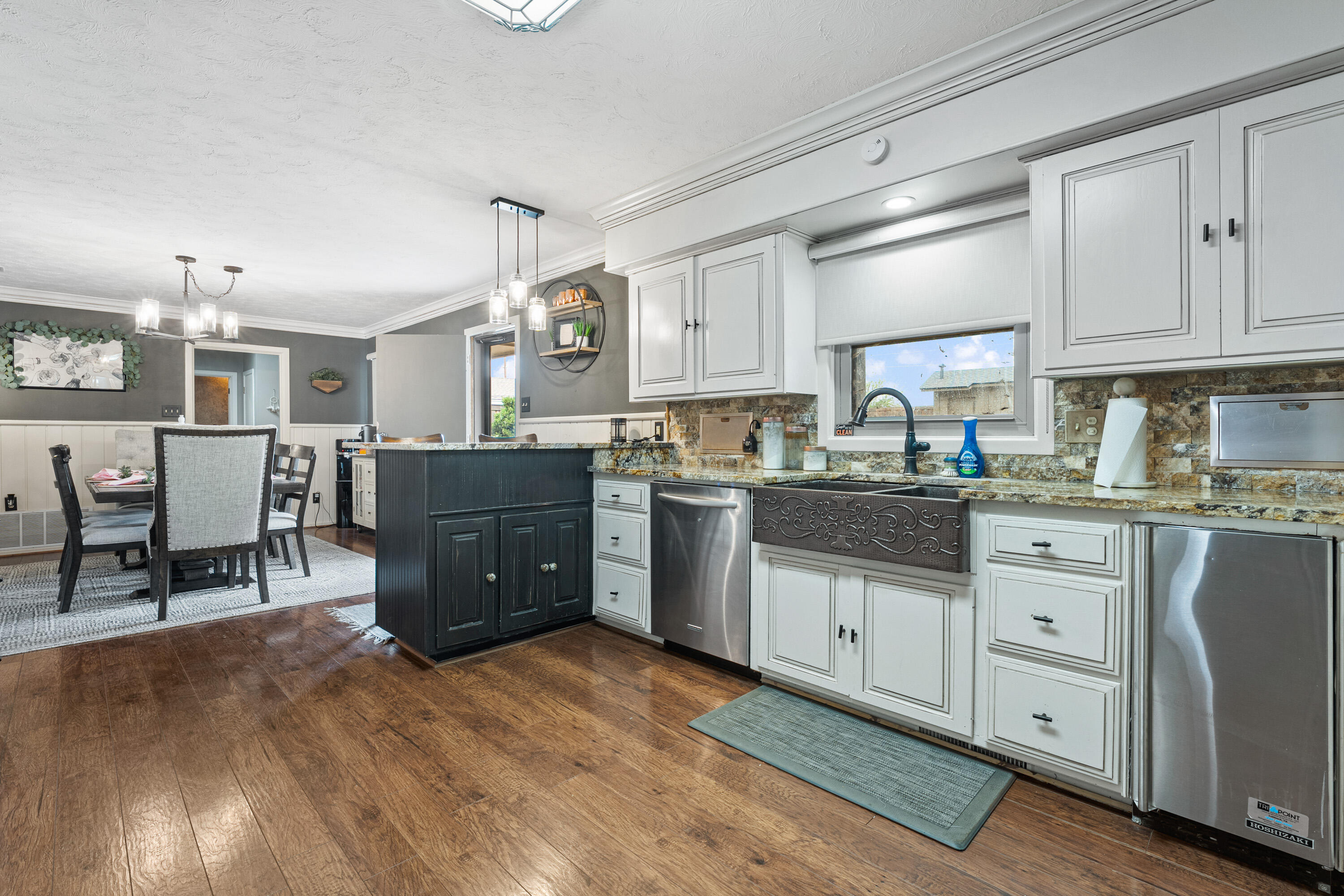 1304 Ave J Ralls, TX 79357 - Photo 13 of 32 a kitchen with granite countertop a refrigerator oven a sink dishwasher and white cabinets with wooden floor