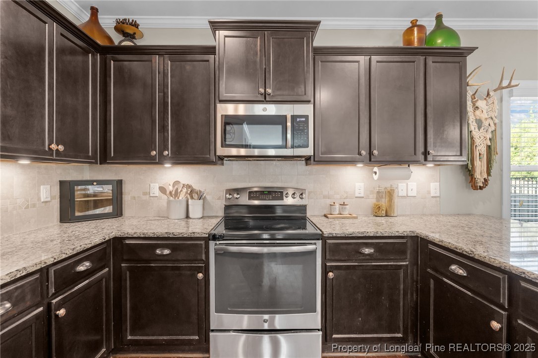 994 Micahs Way North Spring Lake, NC 28390 - Photo 11 of 42 a kitchen with granite countertop a refrigerator stove and microwave