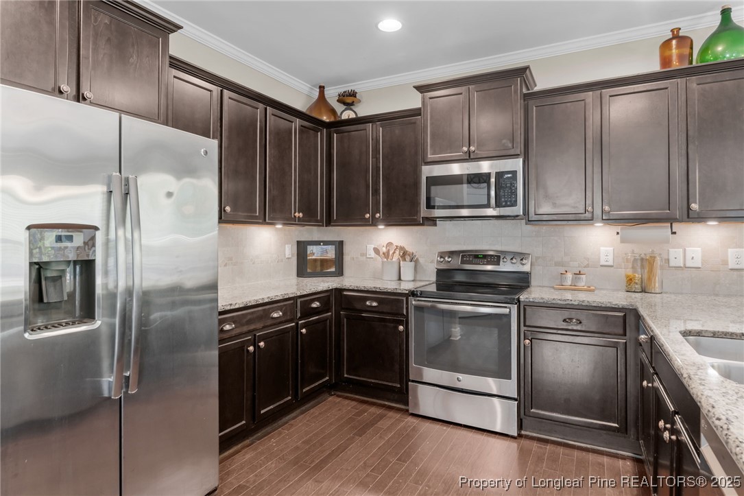994 Micahs Way North Spring Lake, NC 28390 - Photo 12 of 42 a kitchen with granite countertop stainless steel appliances and wooden cabinets