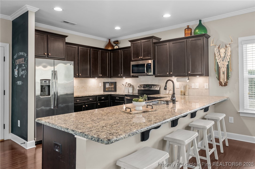 994 Micahs Way North Spring Lake, NC 28390 - Photo 14 of 42 a kitchen with stainless steel appliances granite countertop a sink refrigerator and cabinets
