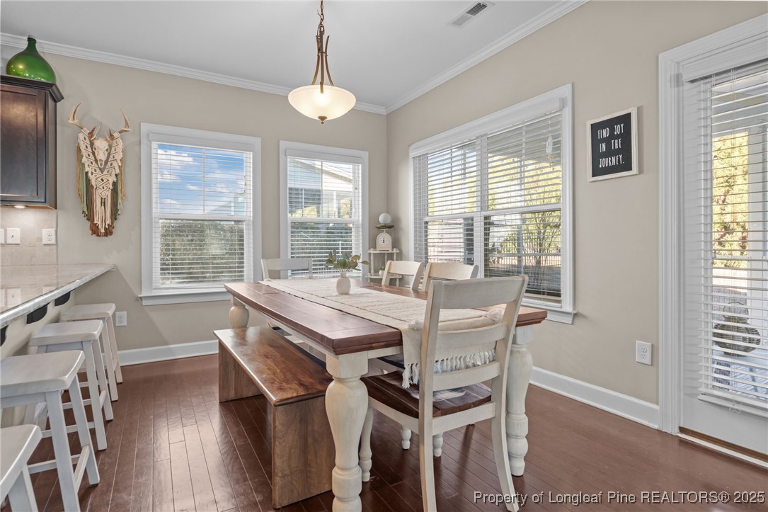 994 Micahs Way North Spring Lake, NC 28390 - Photo 16 of 42 a view of a dining room with furniture wooden floor and a chandelier