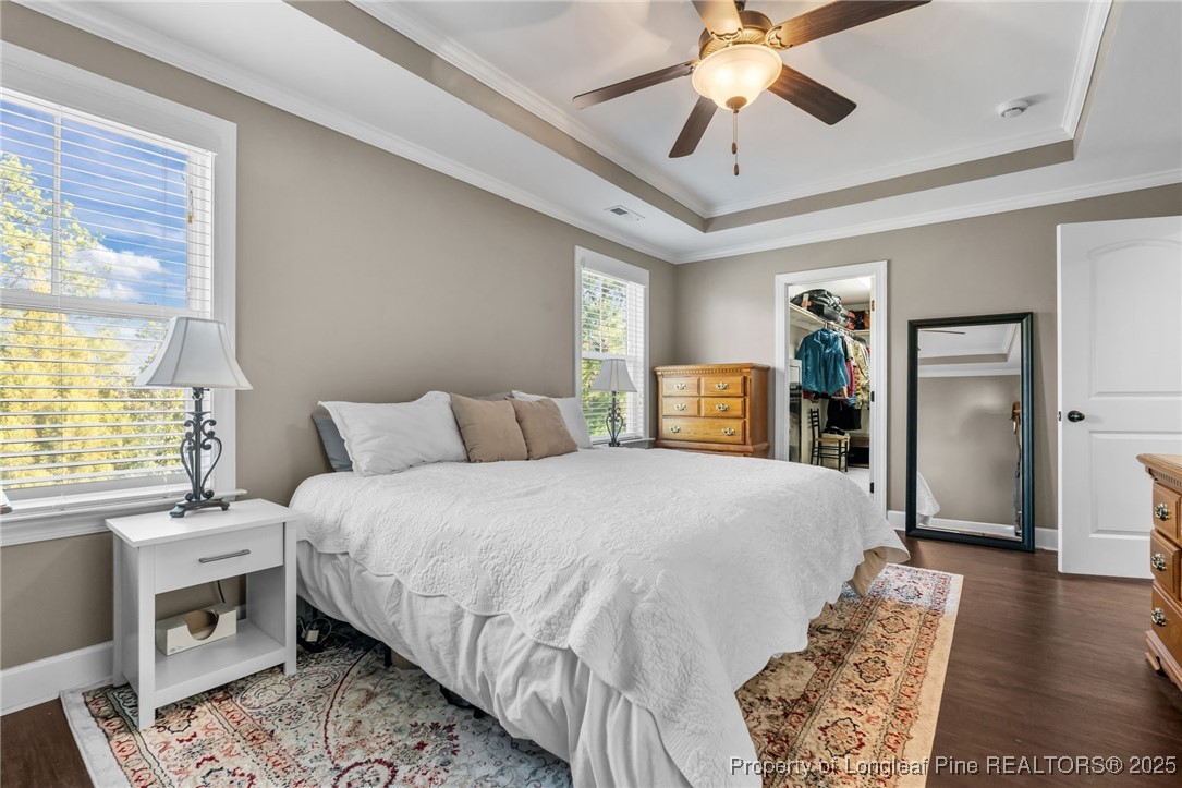 994 Micahs Way North Spring Lake, NC 28390 - Photo 18 of 42 a spacious bedroom with a bed and a chandelier