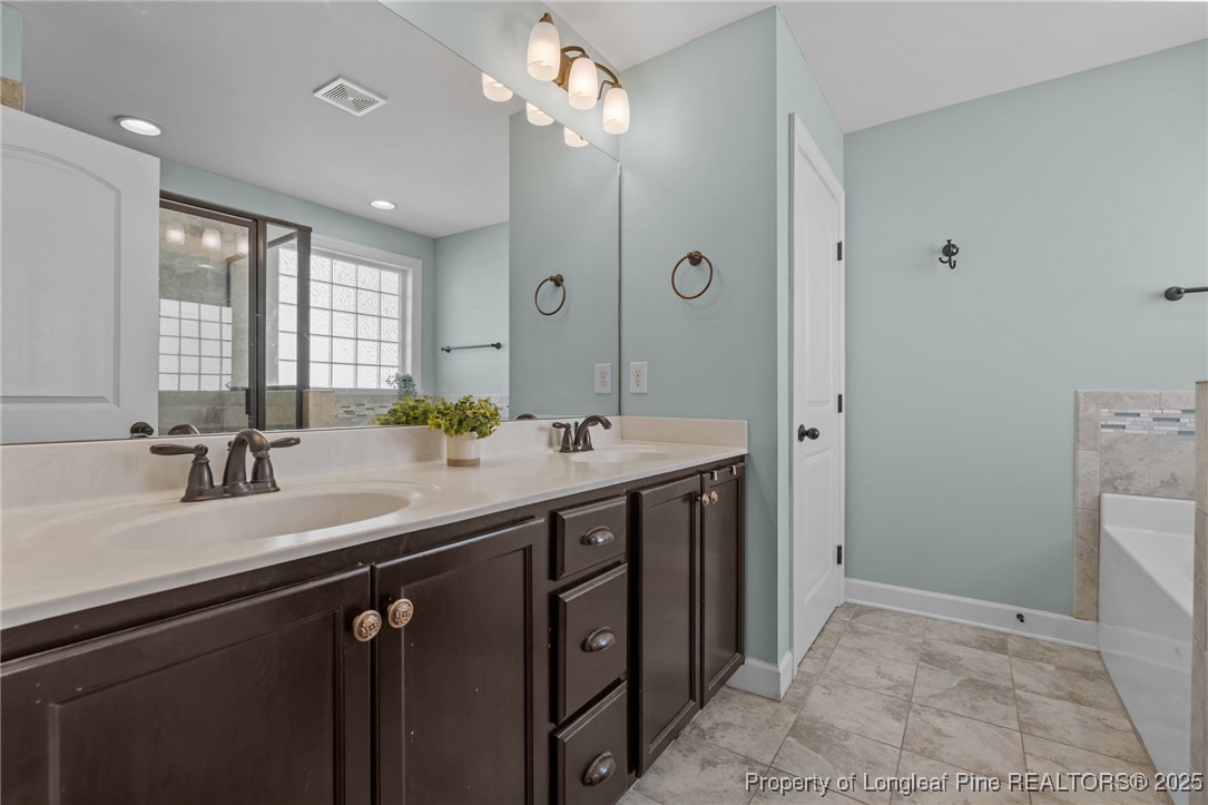 994 Micahs Way North Spring Lake, NC 28390 - Photo 20 of 42 a bathroom with a double vanity sink a mirror and a shower
