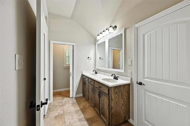 a spacious bathroom with a double vanity sink a mirror and a shower