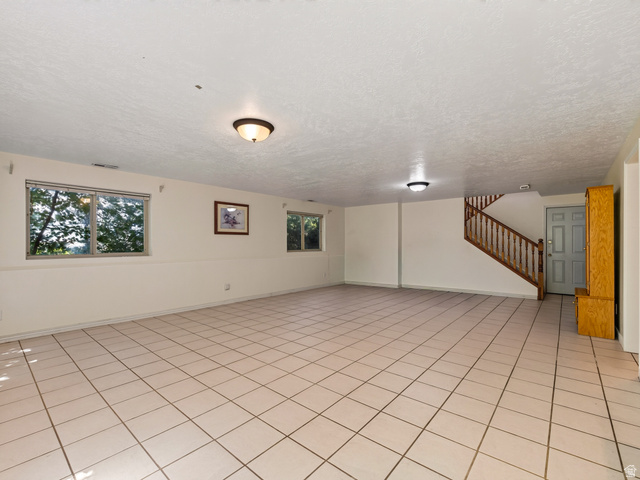 4380 Main Street Logan, UT 84321 - Photo 46 of 74 Spacious room featuring tile flooring, multiple windows, built-in wooden staircase, and overhead lighting fixtures