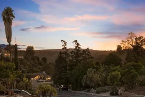 an aerial view of residential house with parking and trees