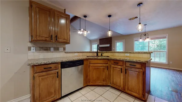 a kitchen with kitchen island granite countertop wooden cabinets and a sink