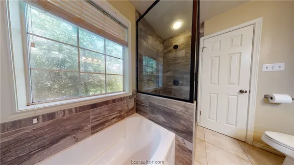 a bathroom with a large tub and shower