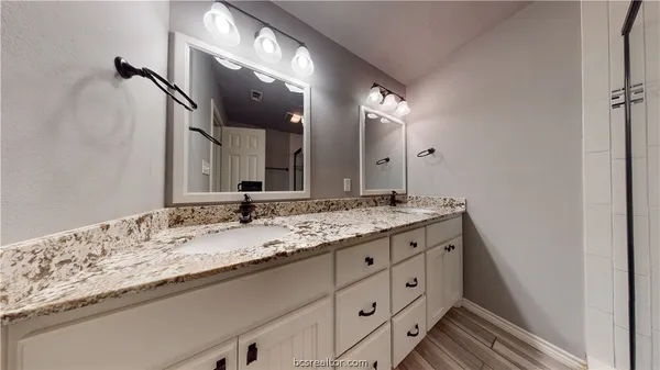 a bathroom with a granite countertop sink vanity and a mirror