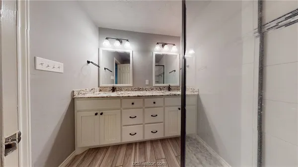 a bathroom with a double vanity sink and mirror