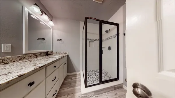 a bathroom with a granite countertop sink and a mirror
