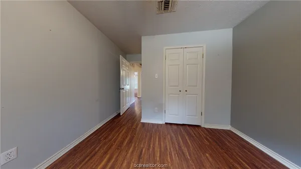 a view of a hallway with wooden floor