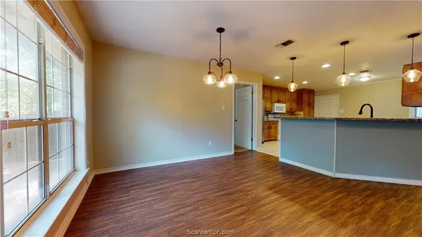 a view of a kitchen with wooden floor and a large window
