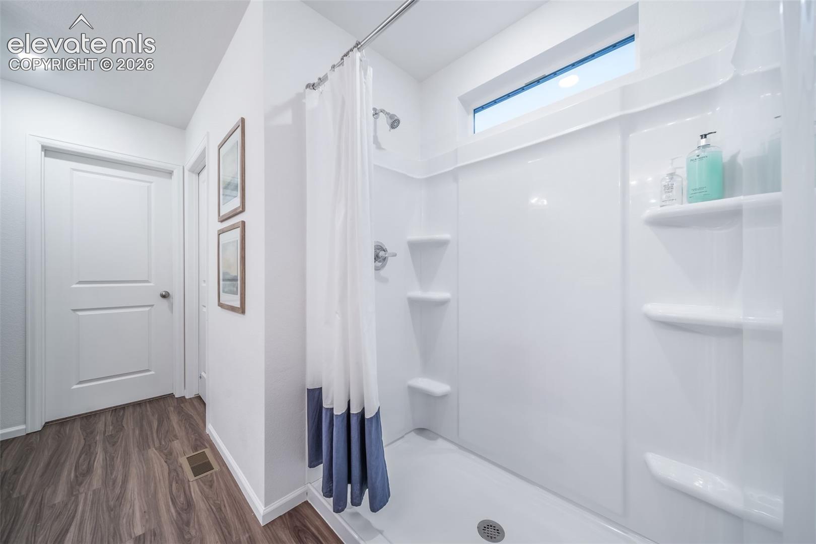 4936 Truscott Road Colorado Springs, CO 80925 - Photo 32 of 41 Shower-tub combination with integrated shelving, chrome fixtures, and a transom window
*photos of a model home*