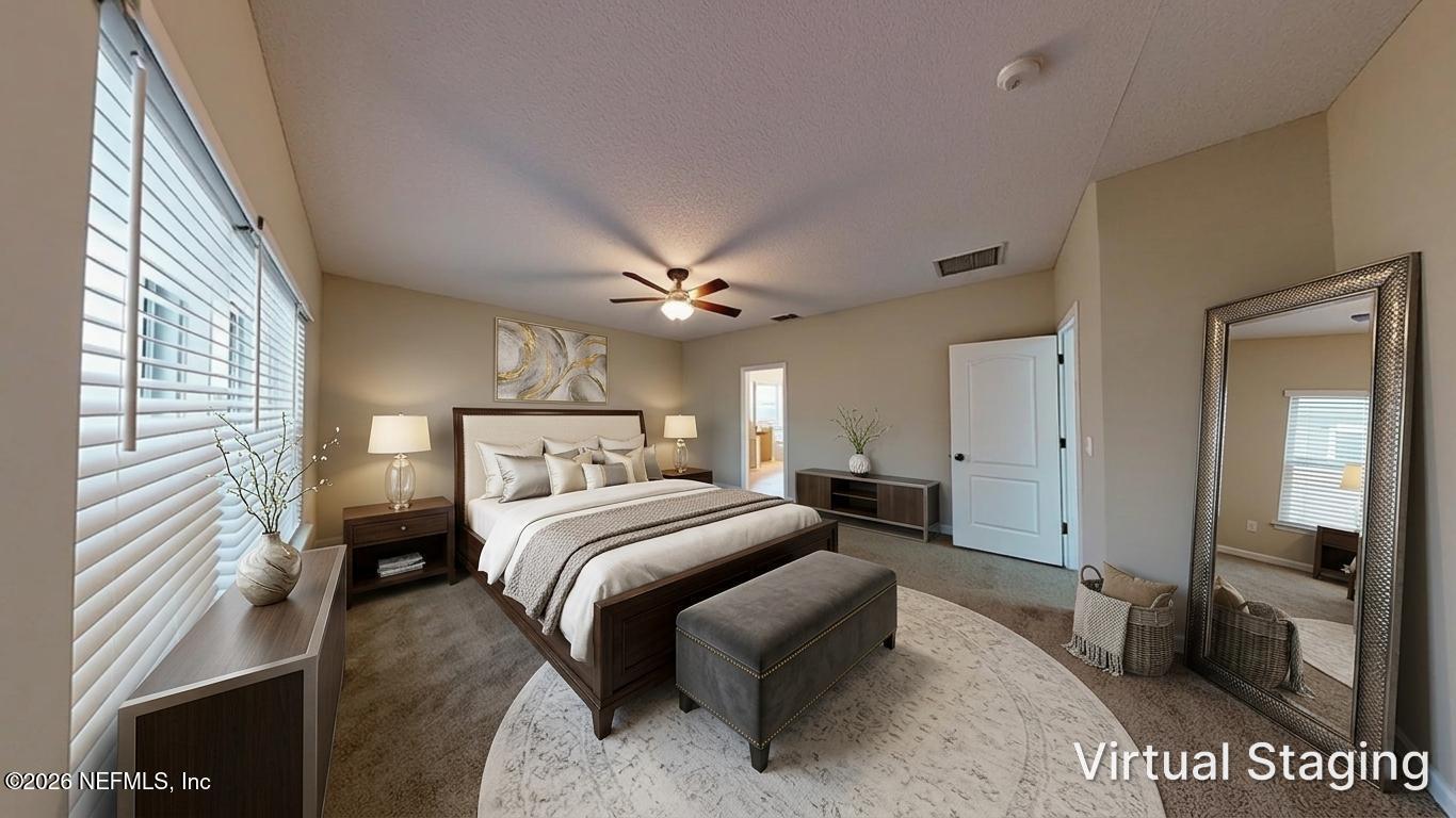 14454 Millhopper Road Jacksonville, FL 32258 - Photo 22 of 44 a bedroom with a large bed and a chandelier