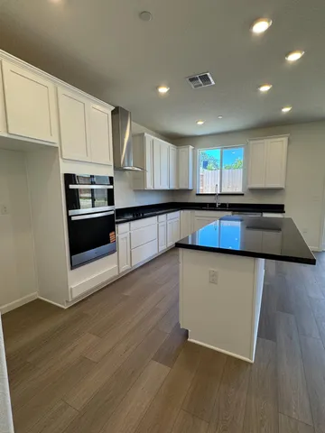 a kitchen with stainless steel appliances granite countertop a stove a sink and a microwave