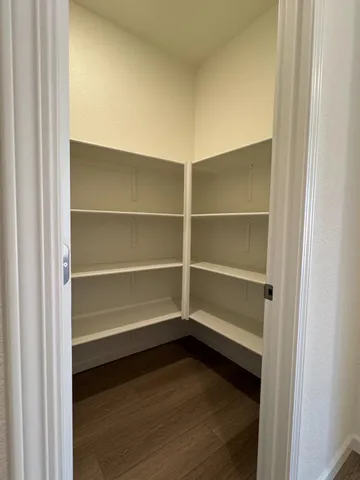 a view of walk in closet with empty racks