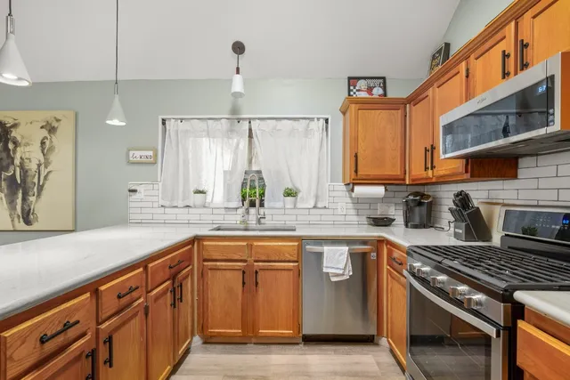 a kitchen with stainless steel appliances granite countertop a sink stove and cabinets