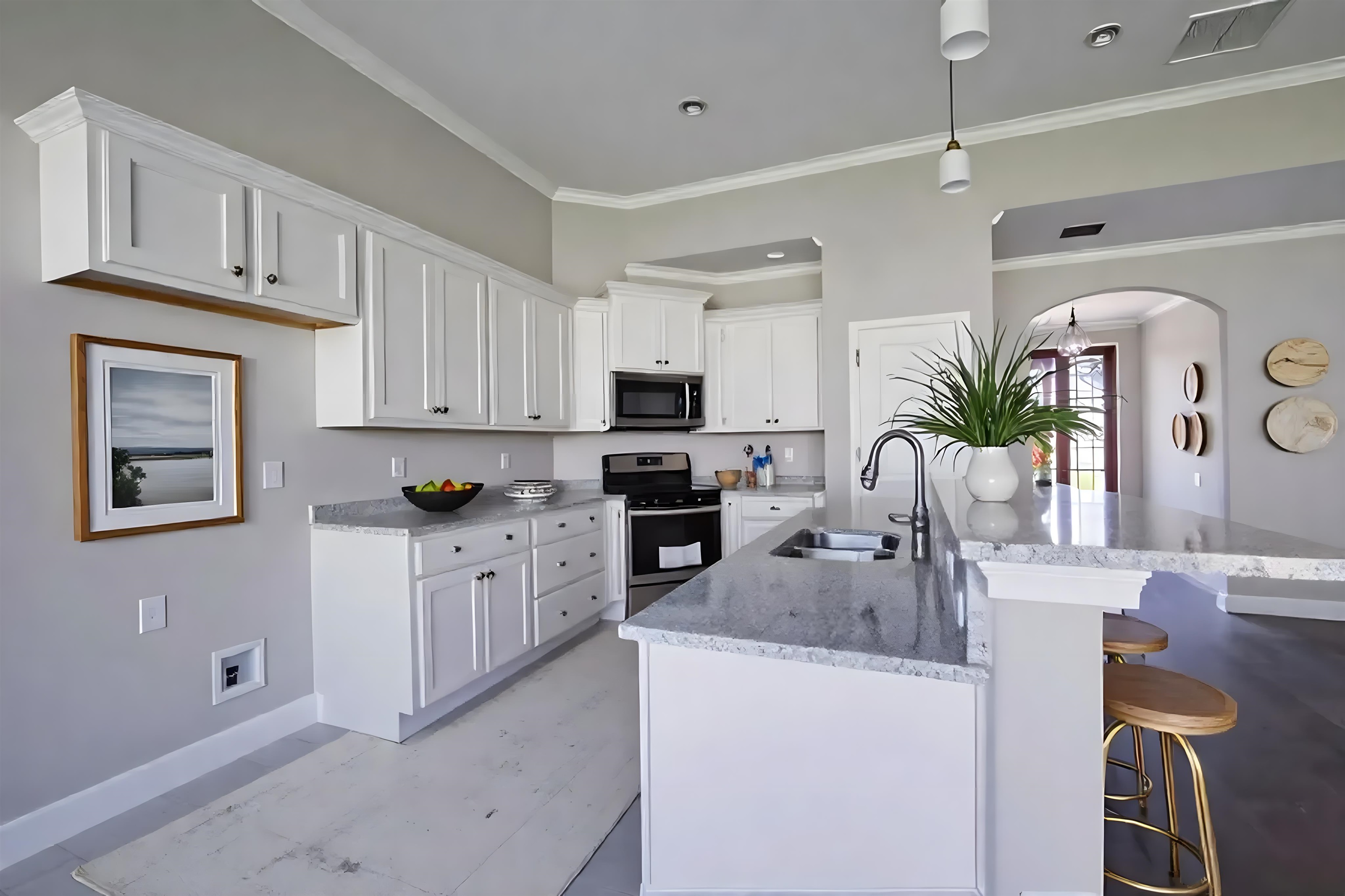 55 Misty Rdg Loop Oakland, TN 38060 - Photo 13 of 38 Kitchen featuring stainless steel electric stove, white cabinetry, arched walkways, light stone countertops, and a kitchen bar