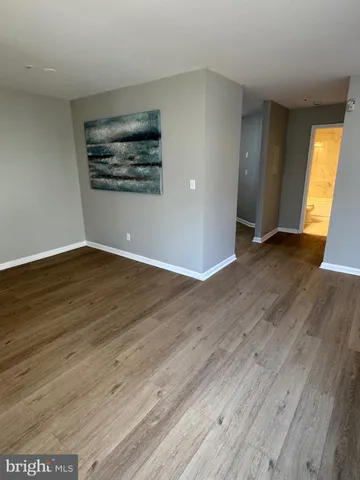 a view of a big room with wooden floor and windows
