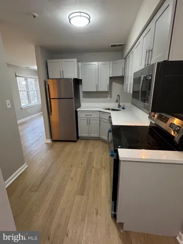 a kitchen with a sink a refrigerator a microwave and cabinets