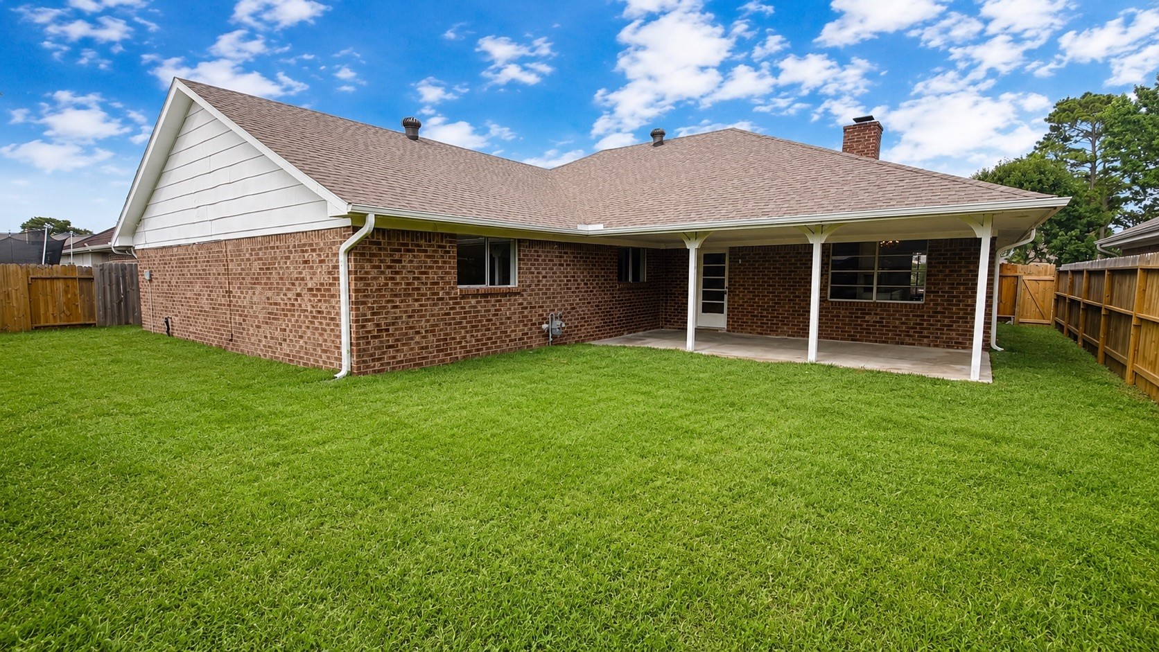 4418 Ponca Street Pasadena, TX 77504 - Photo 22 of 23 Fenced backyard with green space and a covered patio off the rear of the home. (image has been enhance for marketing purposes)